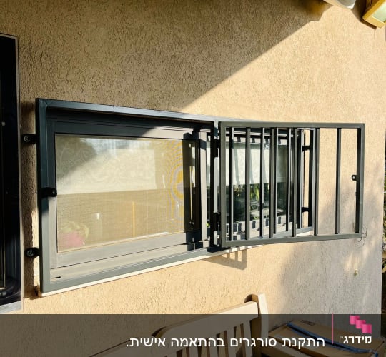 מסגרת חלון מתכתית עם סורגים פתוחים על קיר חיצוני